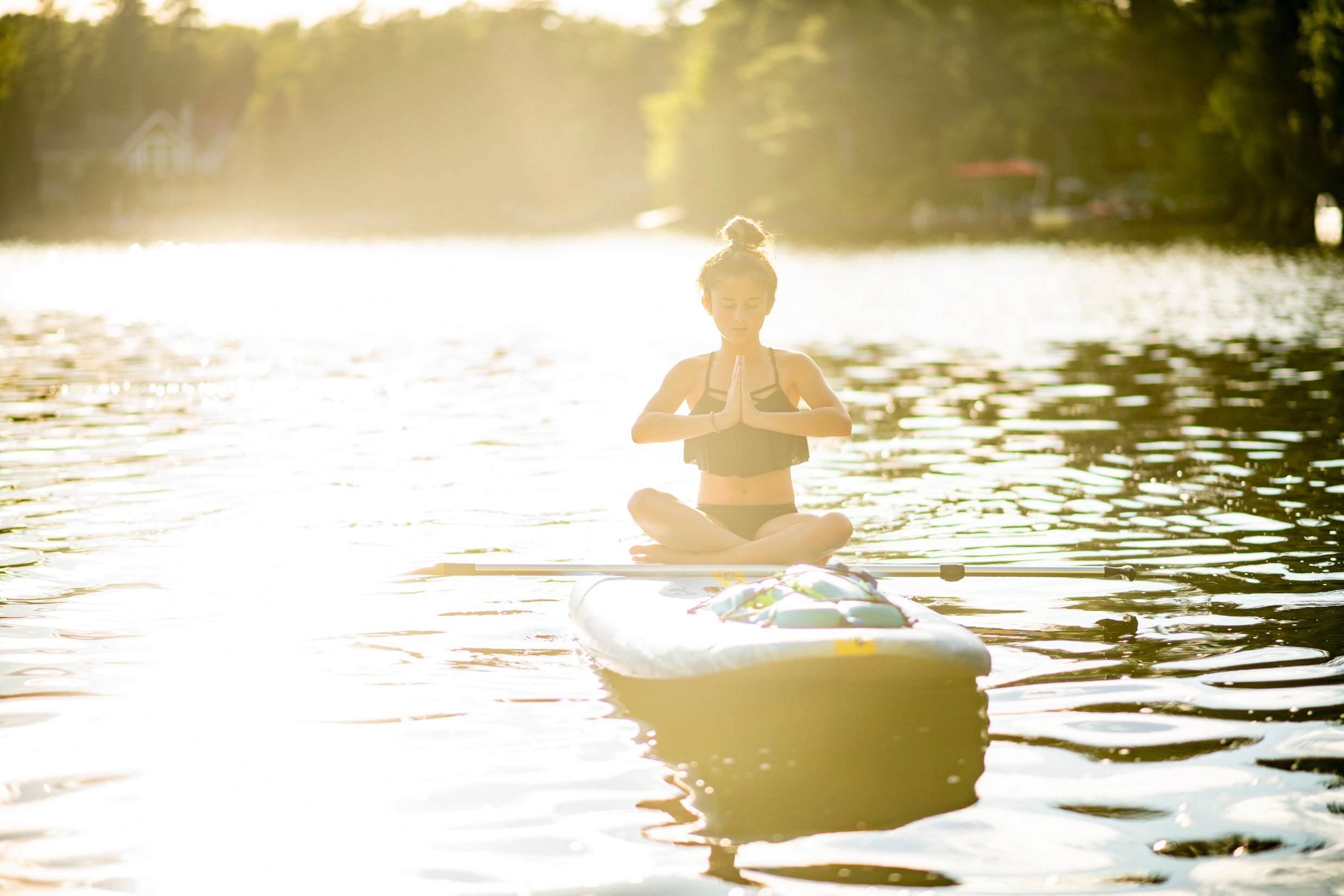 Young girl does yoga on paddle board